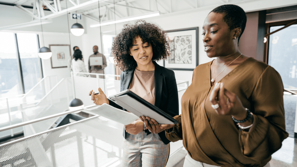 Two female paralegals having a direct workplace conversation to resolve issues and lower new paralegal anxiety.