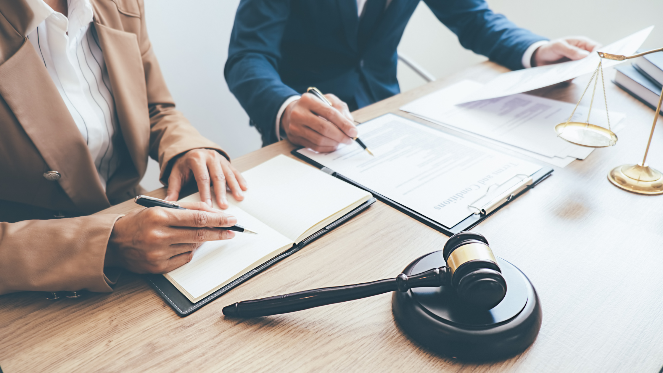 Two paralegals working seriously at work in a defense firm showing the difference between working for a plaintiff vs defense firm.