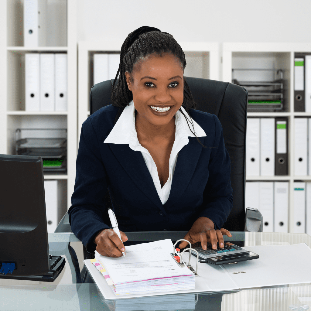 A professional personal injury paralegal smiling confidently as she works with her calculator after the paralegal team training.