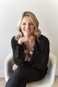 An image of Ann Pearson, sitting on a chair with a cheerful expression for the billable hour course on the paralegal bootcamp.