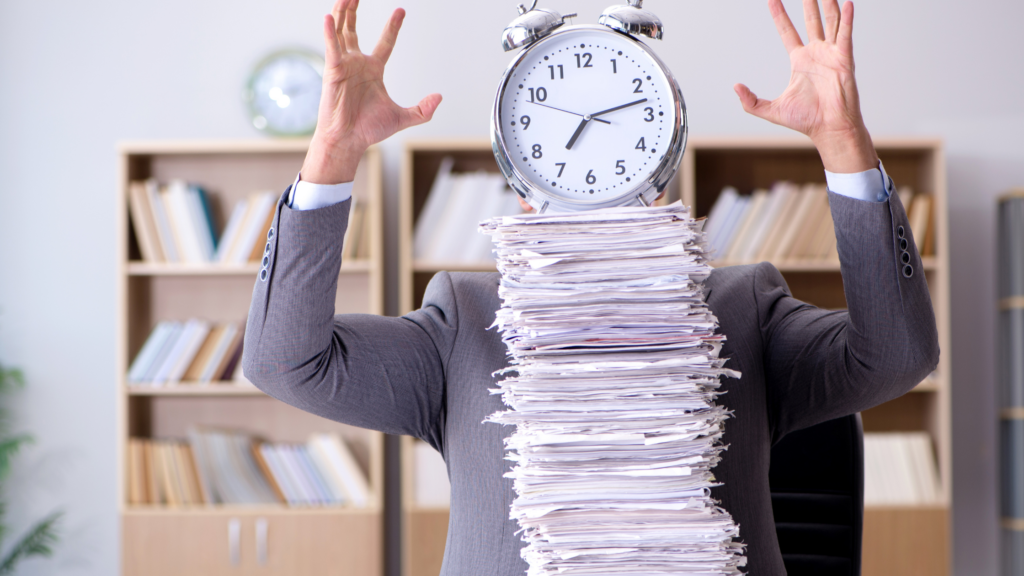 A paralegal lost behind his pile of work depicting his billable hour struggle.
