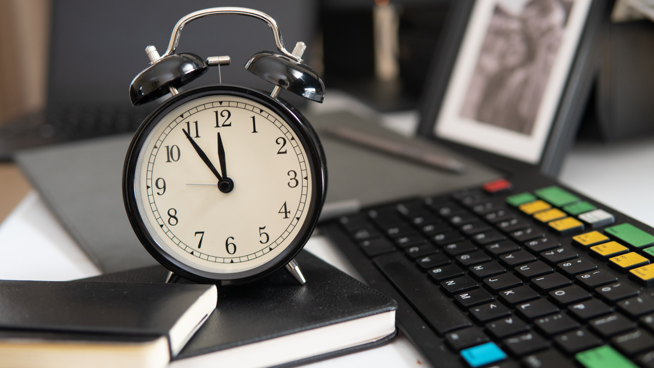 A clock, writing materials, and calculator on a desk shows materials needed to calculate and draft billable hours for paralegals.