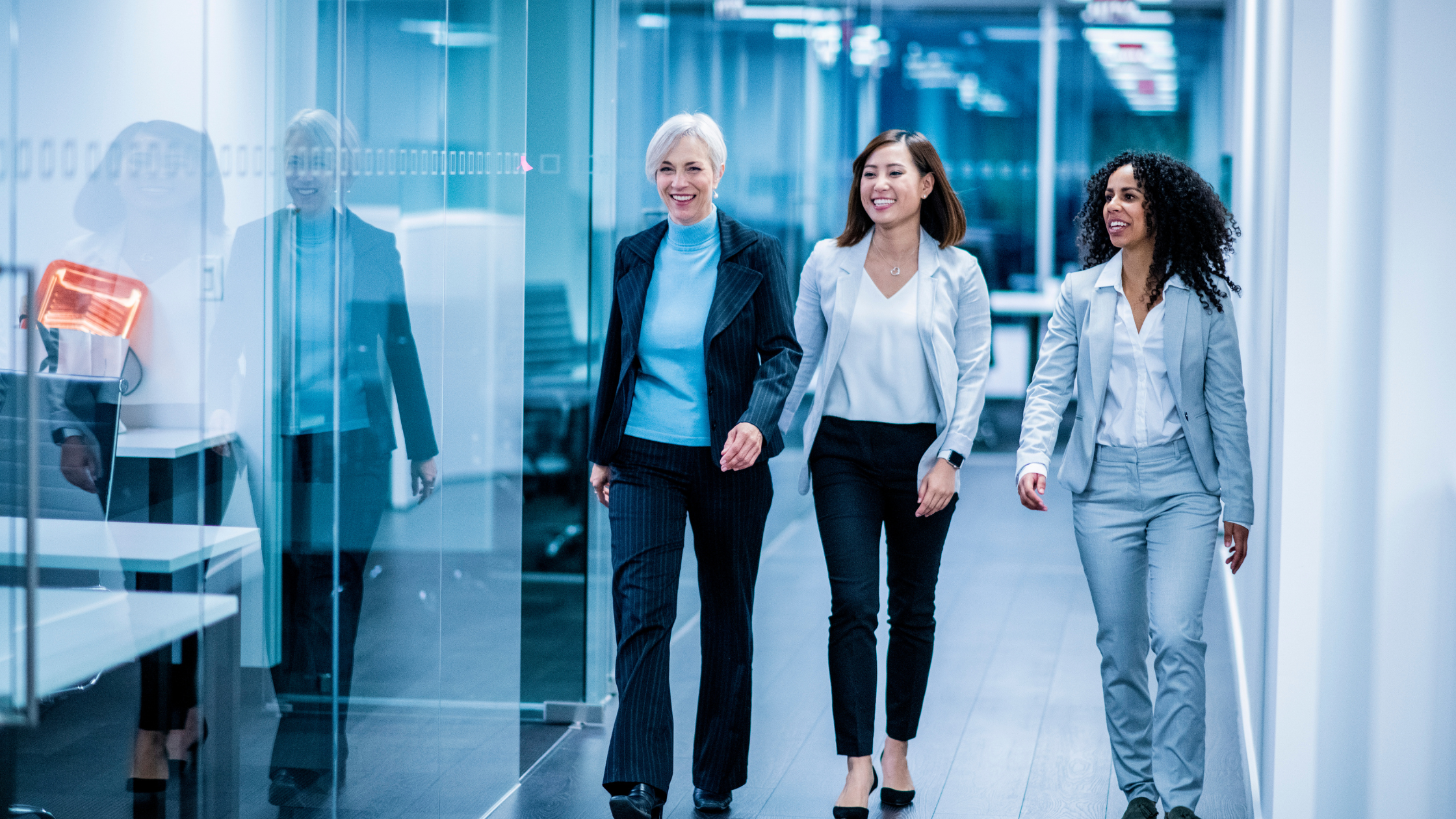 Three paralegals walking through a firm's hallway with confidence because they have the habits of the indispensable paralegal.