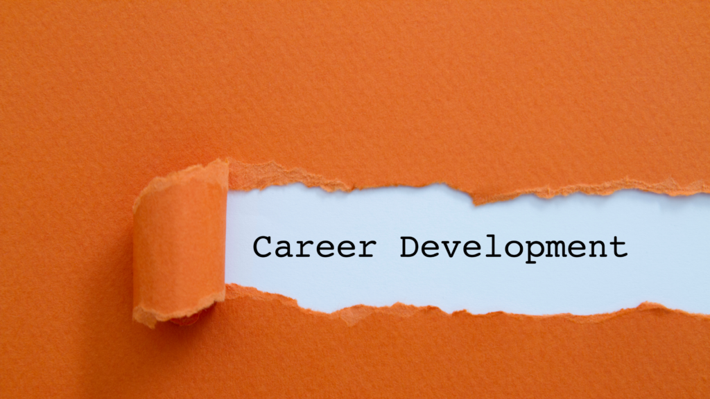 A torn cardboard exposes the phrase career development to emphasize the need for a career development plan.
