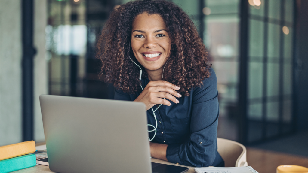 A paralegal sits at her desk and smiles as she learns the case management tips that make her work easier.