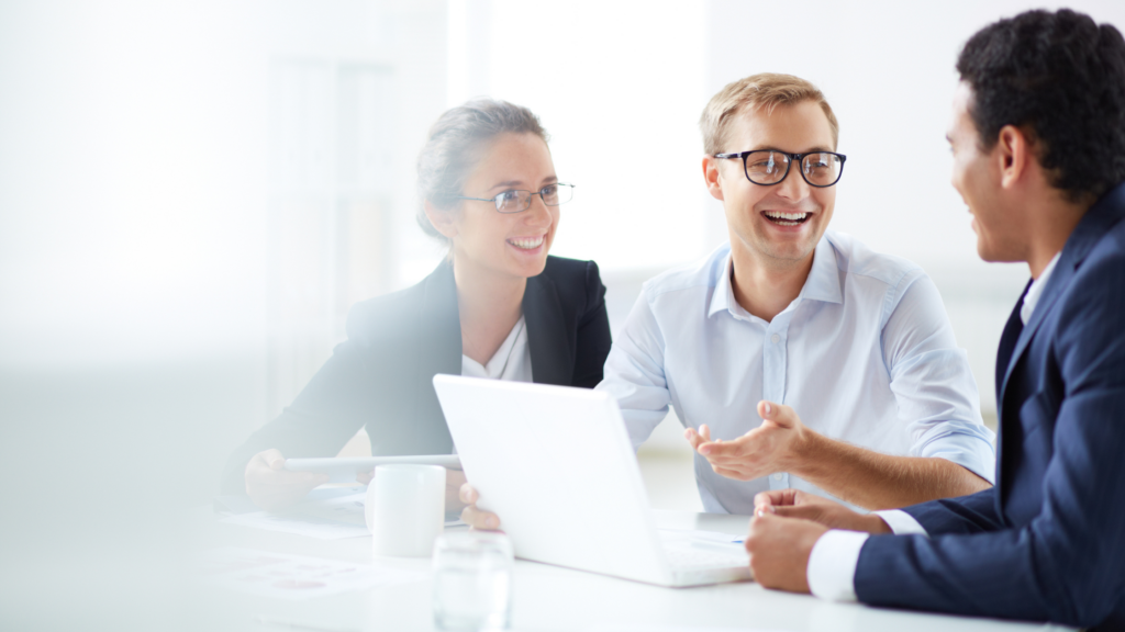 Three paralegals sit at a desk with a computer and discuss the changes they're glad have happened in the paralegal profession.