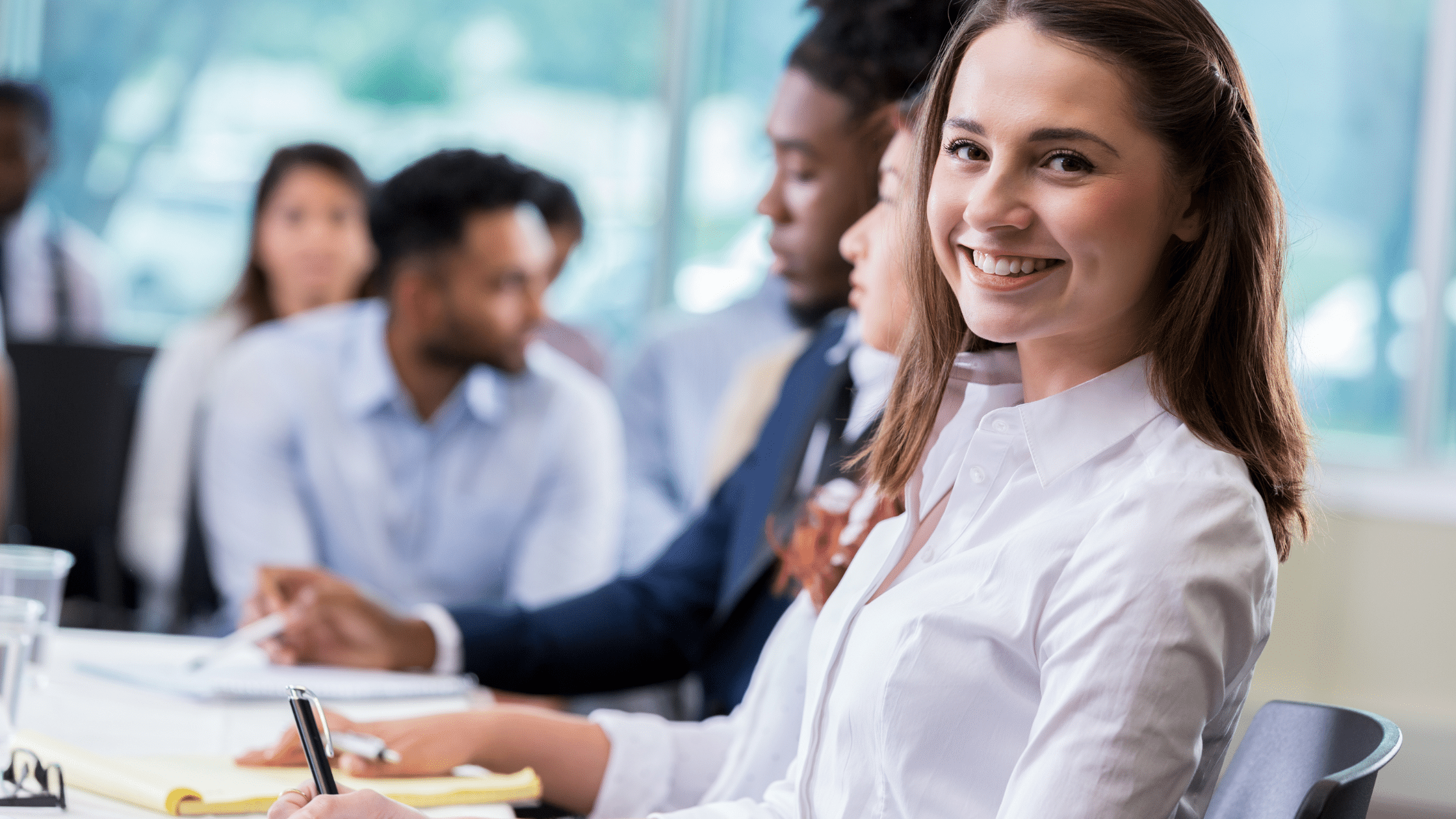 A smiling paralegal among many paralegals in a class showing her enthusiasm at continuing her education as a paralegal.