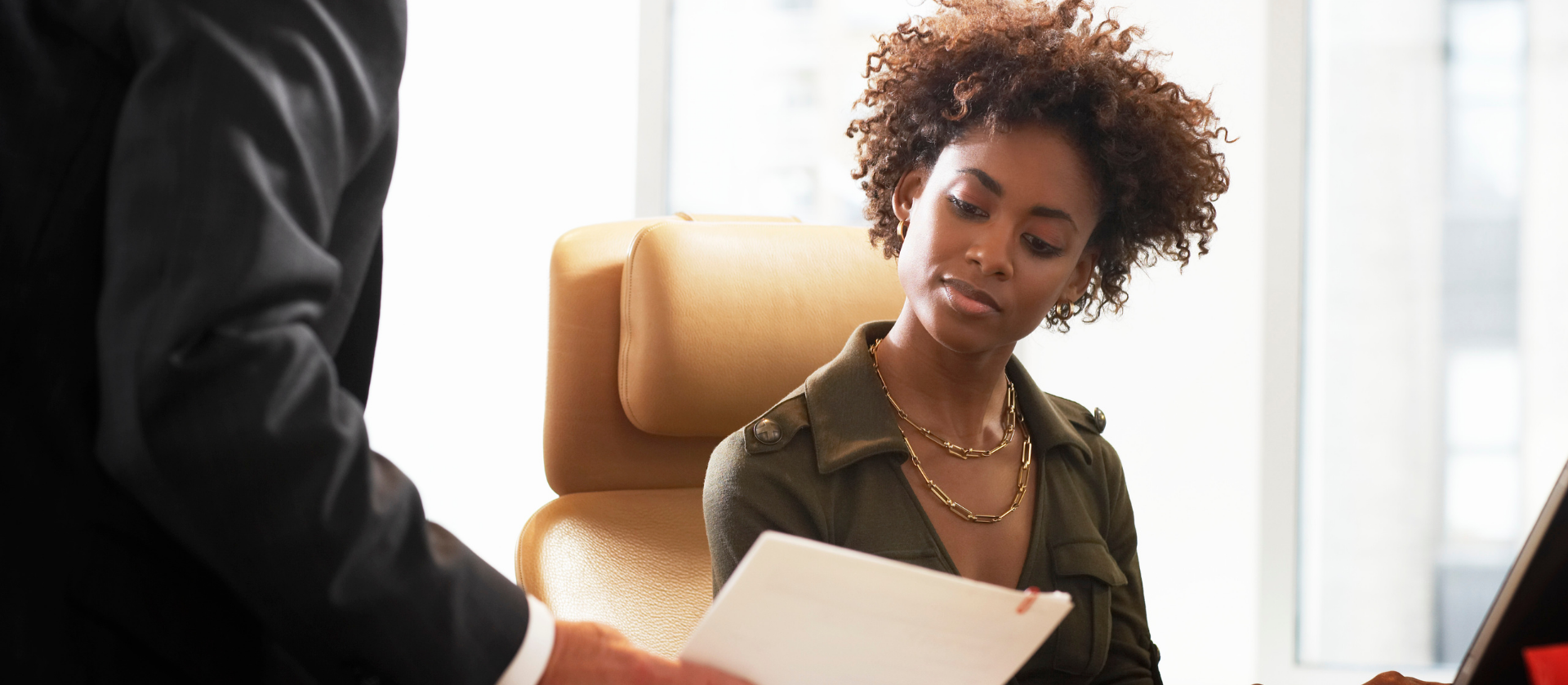 An attorney holds a document in front of a new paralegal and instructs her on the roles of a criminal law paralegal.