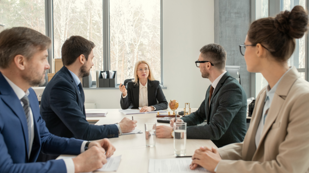 Legal professionals in a defense firm assuming a formal seating arrangement to show their difference from a plaintiff firm.