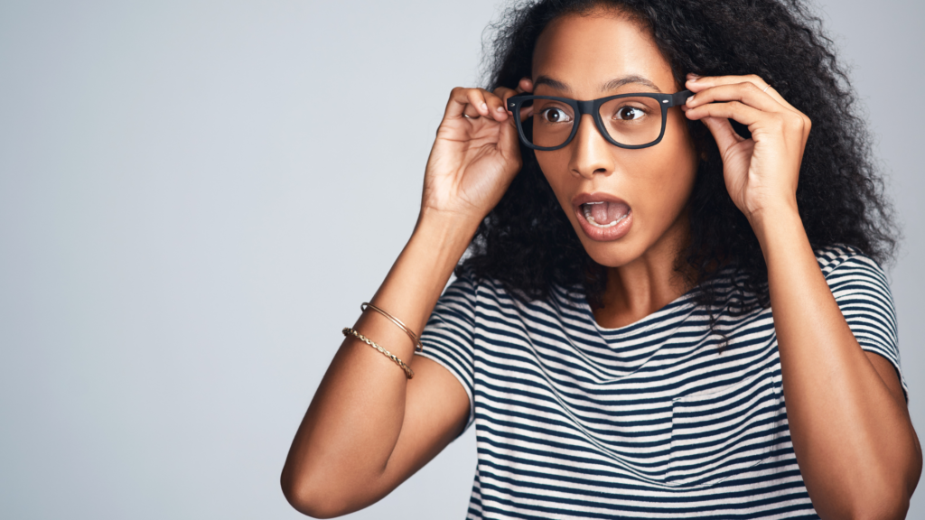 An experienced paralegal holding her glasses and surprised at the numerous errors from a new paralegal who's faking it.