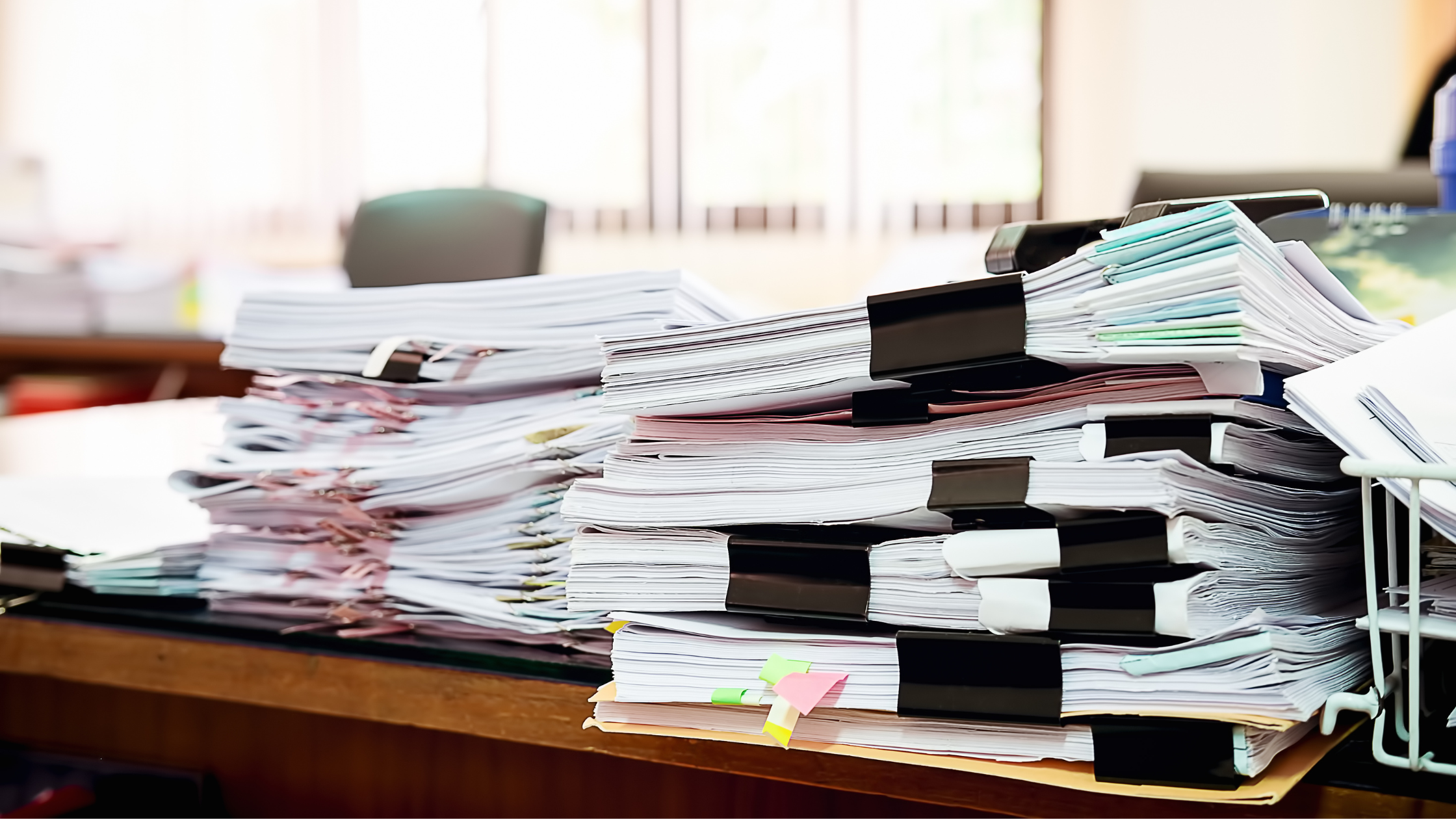 A pile of work on a litigation paralegal's desk that can be avoided with the aid of eDiscovery.
