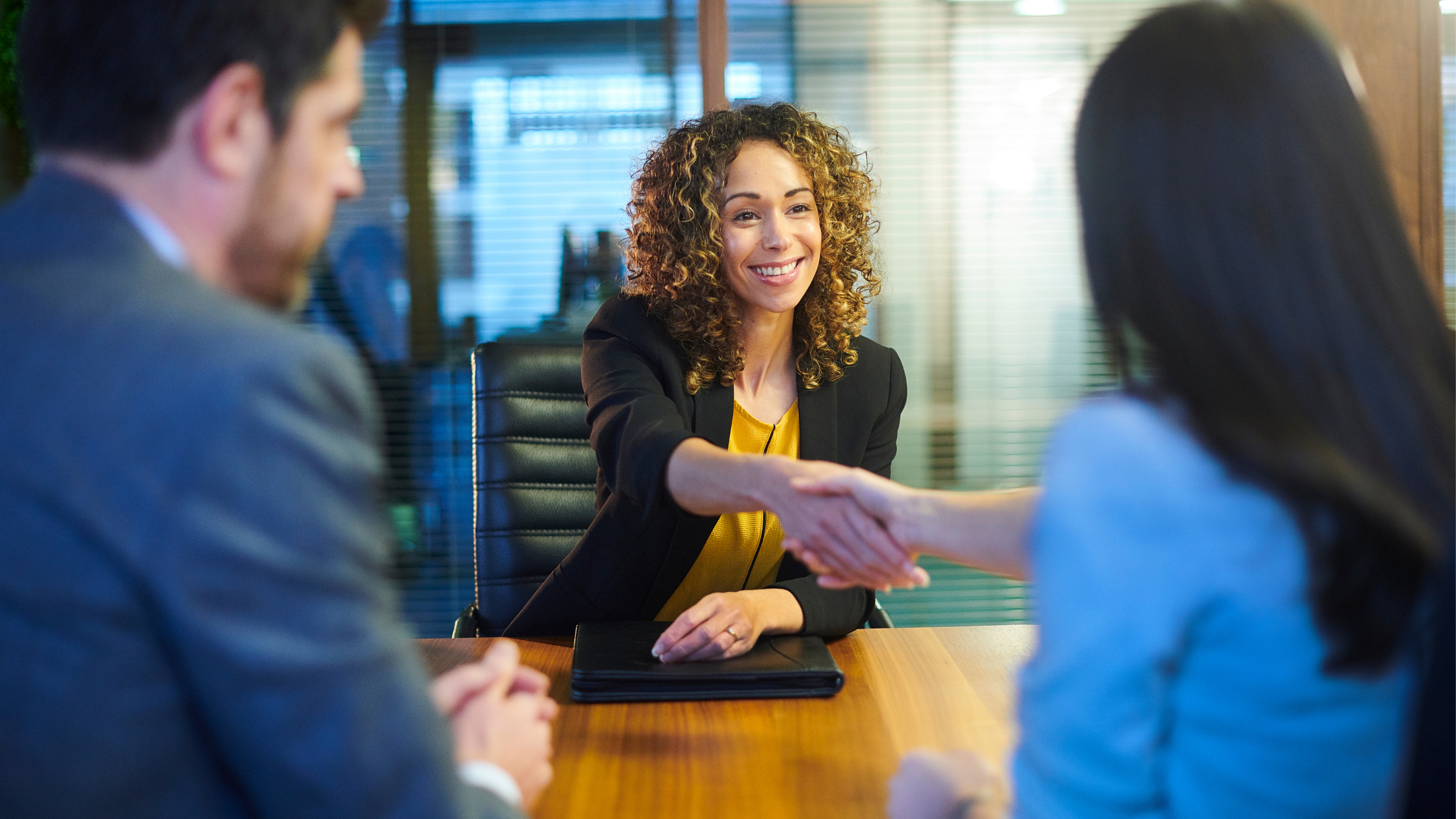 A paralegal shakes hands with an attorney as she lands a new job after transitioning to litigation from another practice area.