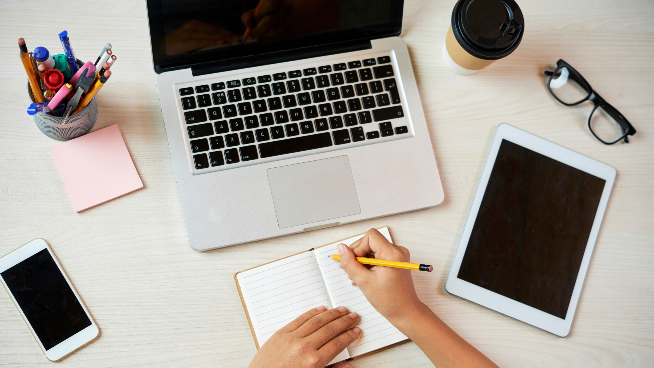 A litigation paralegal sits at her desk and writes in a notepad while her computer is open shows a typically busy day.