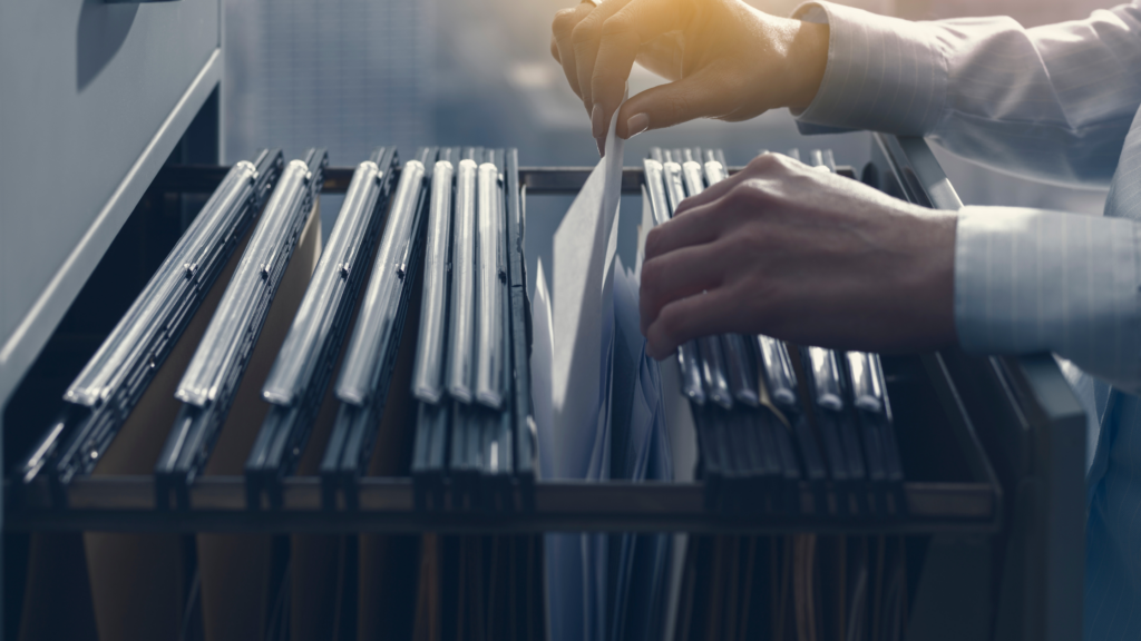 A personal injury paralegal searches for a case file in a drawer to apply the tips for managing personal injury cases.