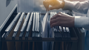 A personal injury paralegal searches for a case file in a drawer to apply the tips for managing personal injury cases.