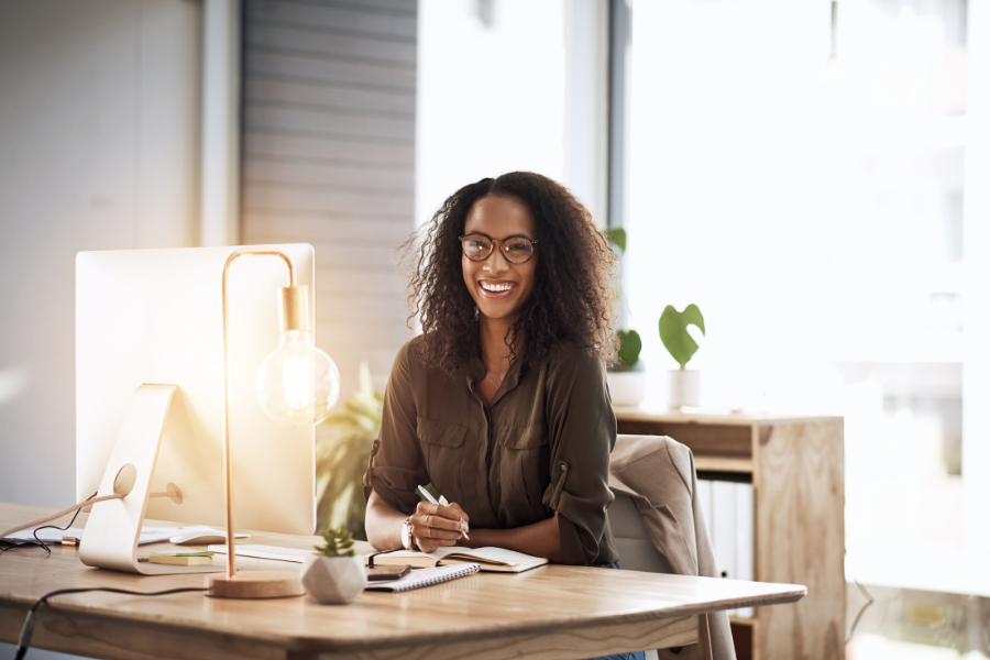 A paralegal poses for a photo in her office with confidence showing what a confident paralegal looks like.