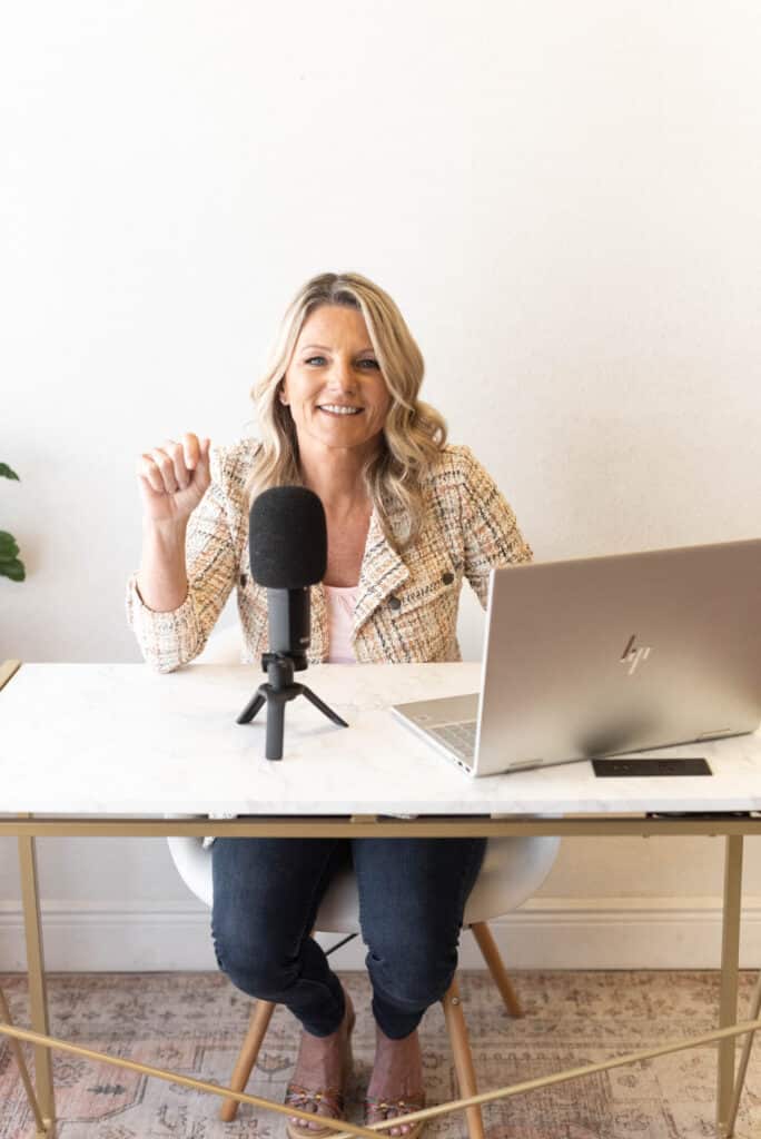 Ann Pearson poses with a computer and a microphone on her desk as she sets to present the paralegal podcast.