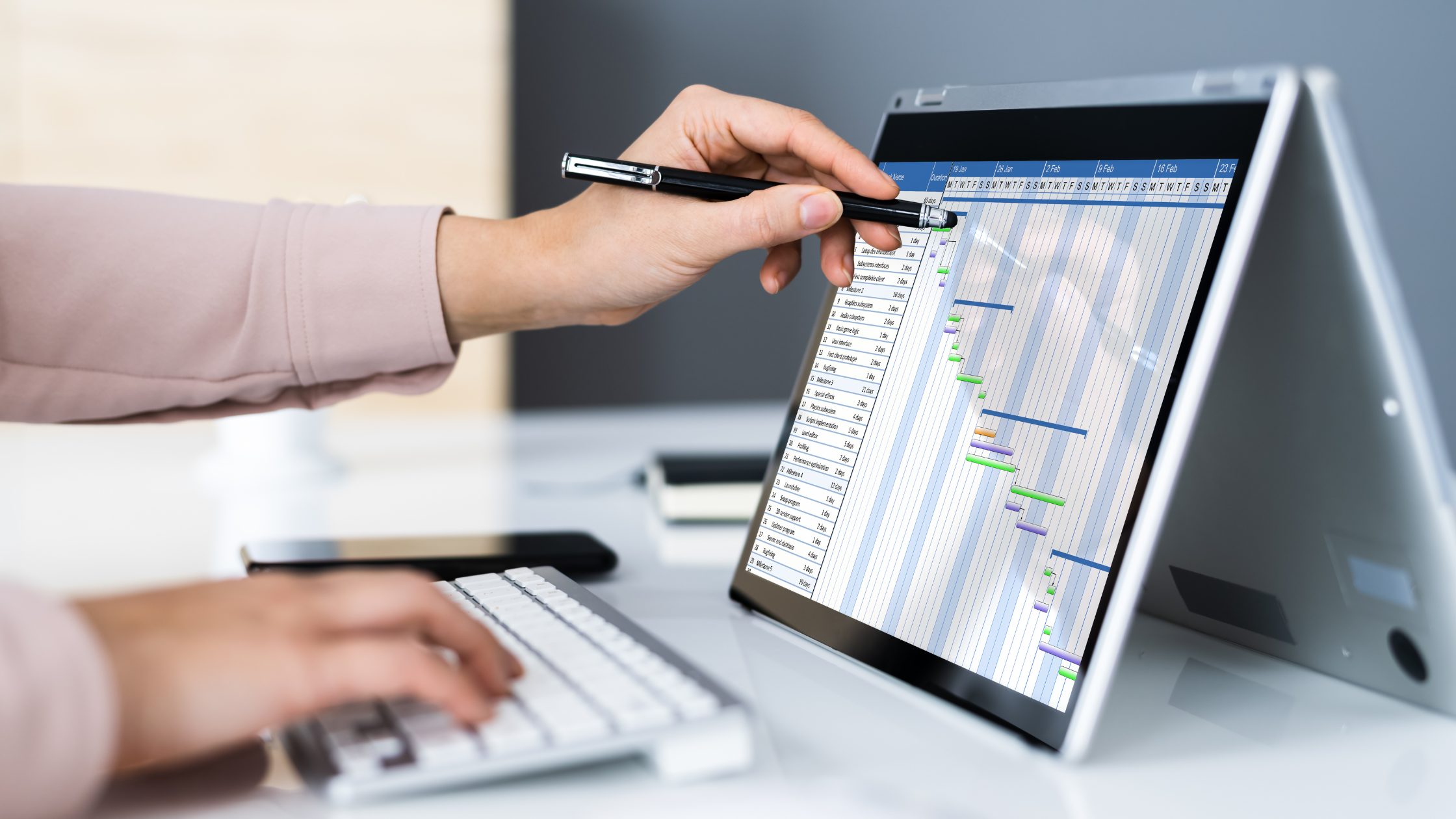 A paralegal using both hands on a computer while managing a project to show its seriousness.