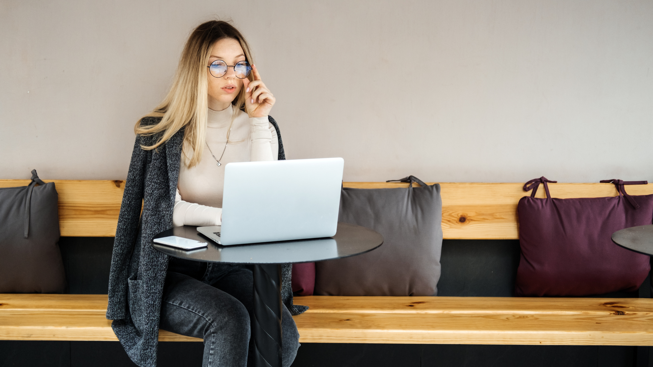 A professional paralegal sits and has a computer on her lap researching profitable side gigs for paralegals.