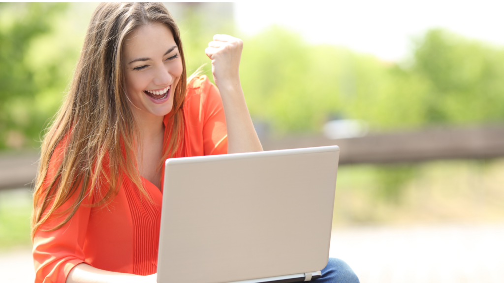 A happy woman laughing at something on her laptop as a form of relaxation