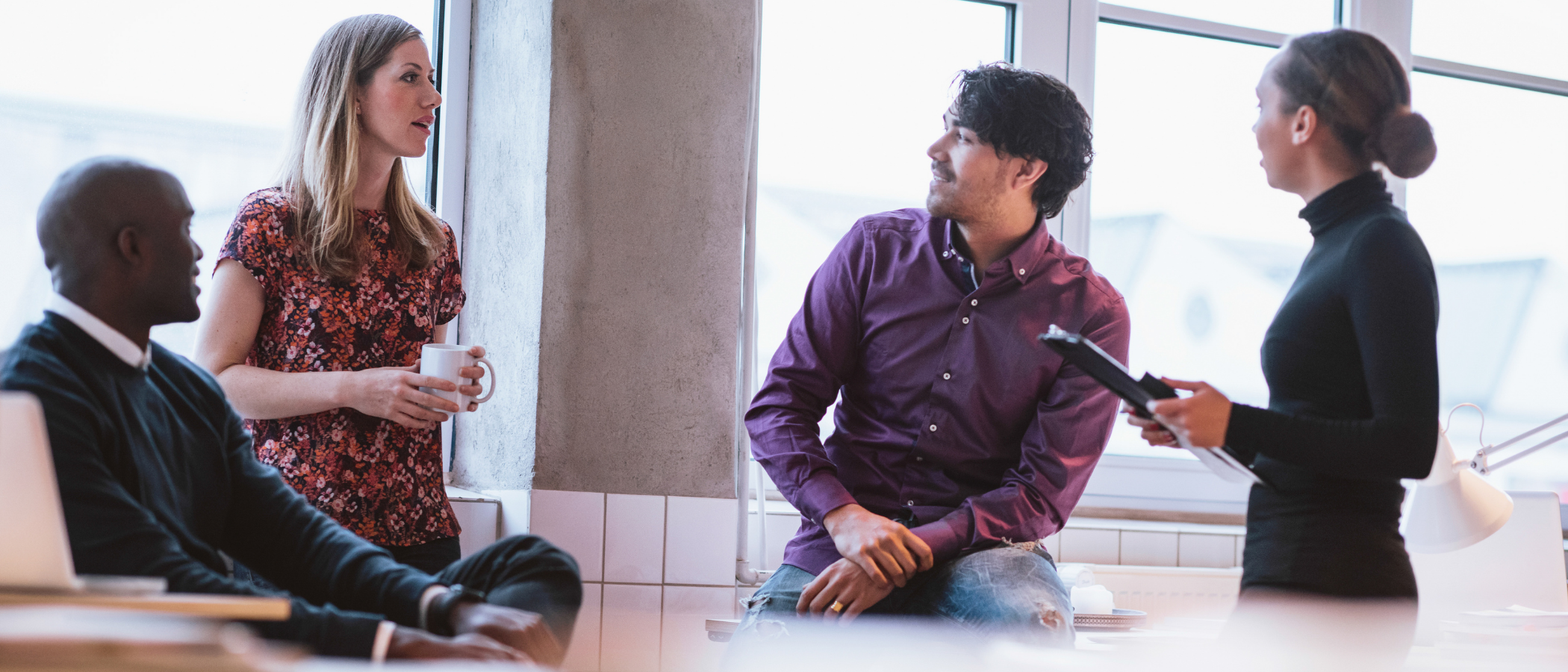 Four paralegals; two men and two women in an informal meeting discussing some matters