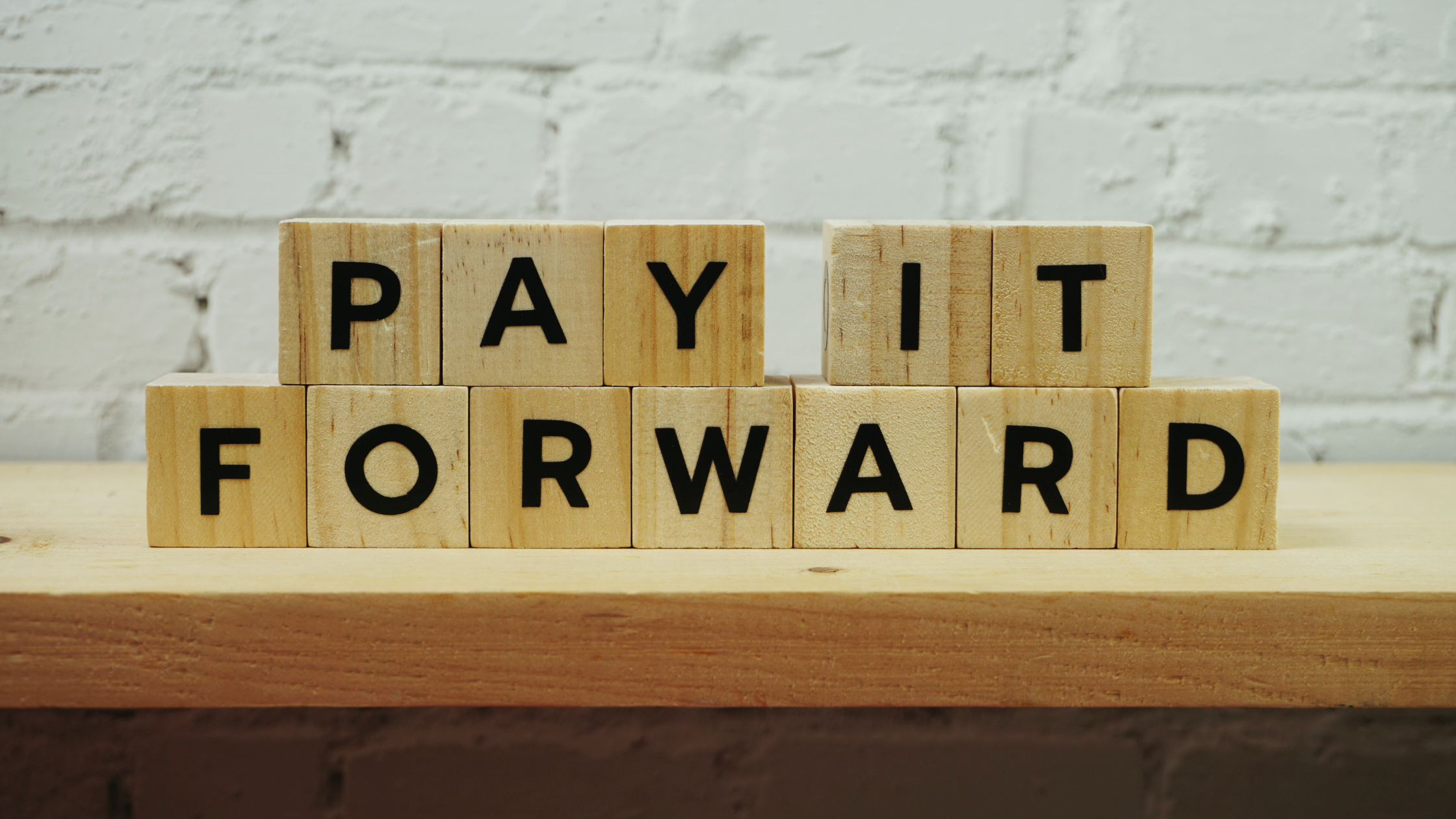 An image of lettered squares that spell out the phrase, pay it forward, for the paragel on fire podcast, episode 6