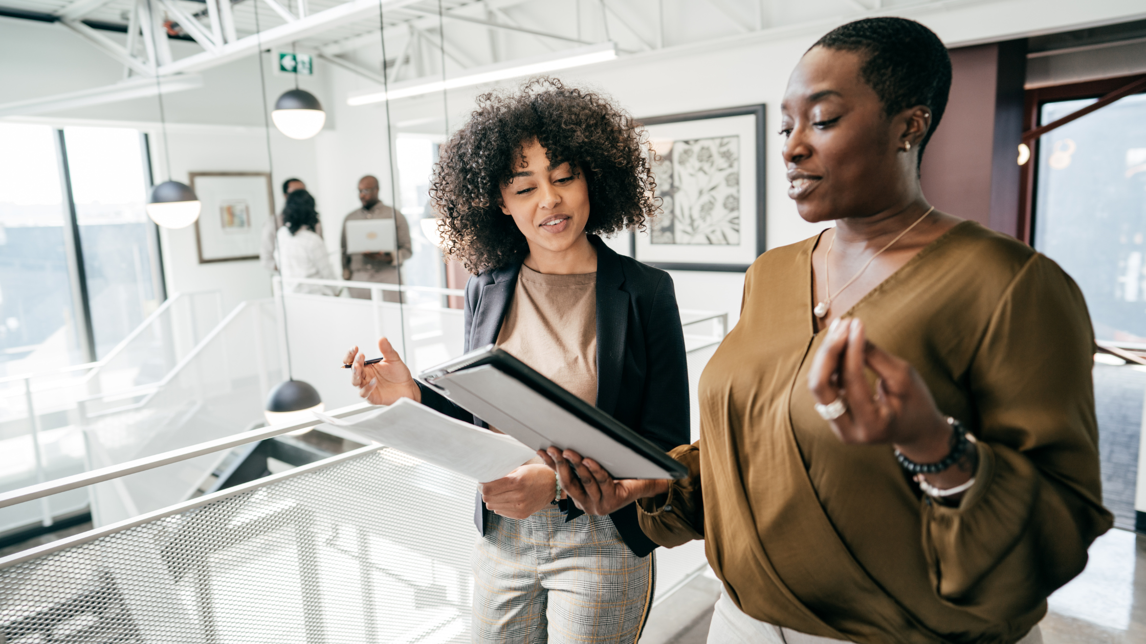 Two paralegals discussing the content of a document depicting what a proactive paralegal looks like.