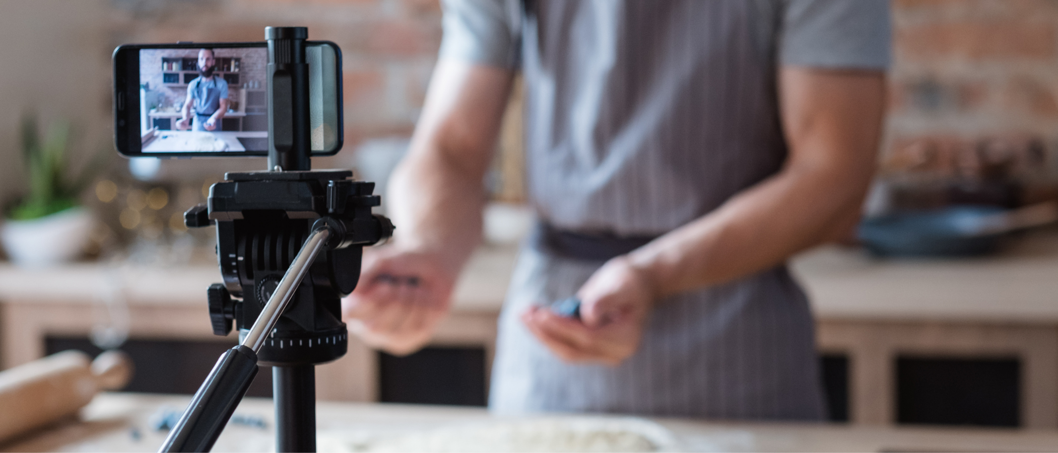 A chef making a cooking vlog with a selfie tripod and phone