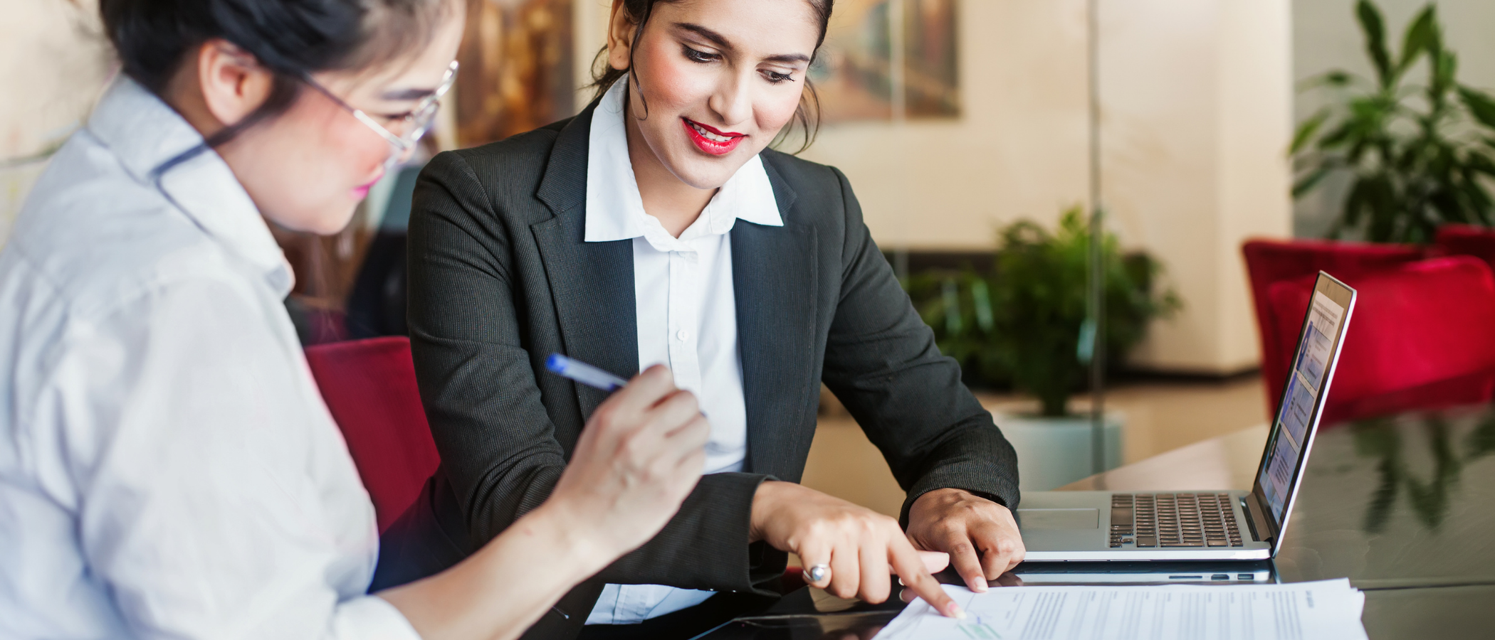 A paralegal explaining the details of a notary document to her client in a lobby