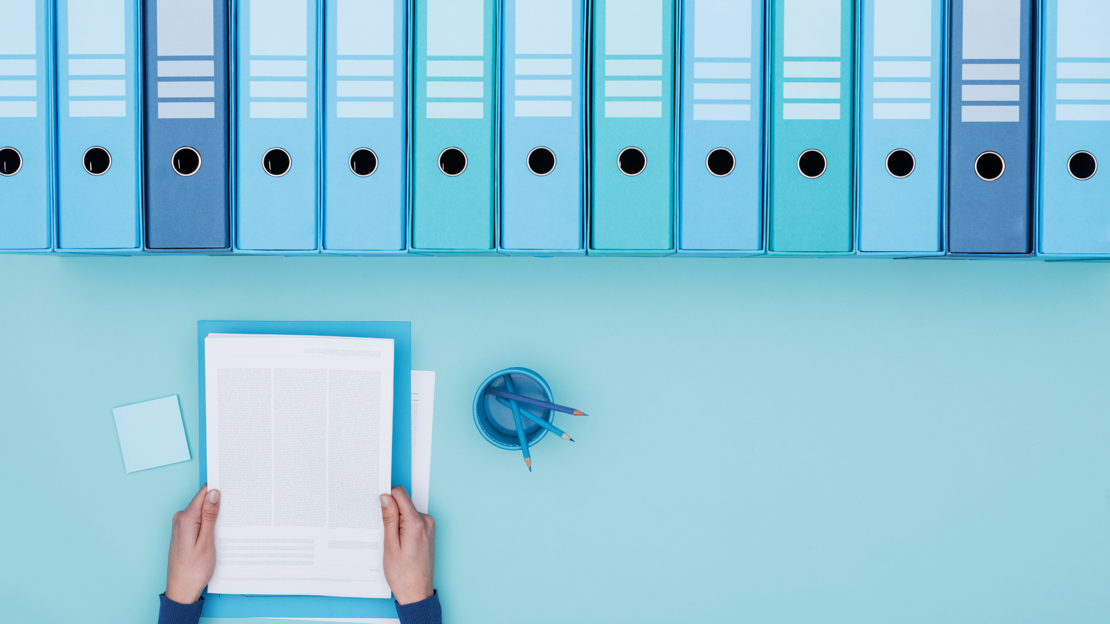 A paralegal handles some documents and prepares them to be put in a trial binder like the other documents already in their binders.