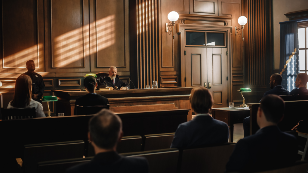 A paralegal sitting in a courtroom after ensuring the evidence for trial has been arranged properly during the pre-trial phase.