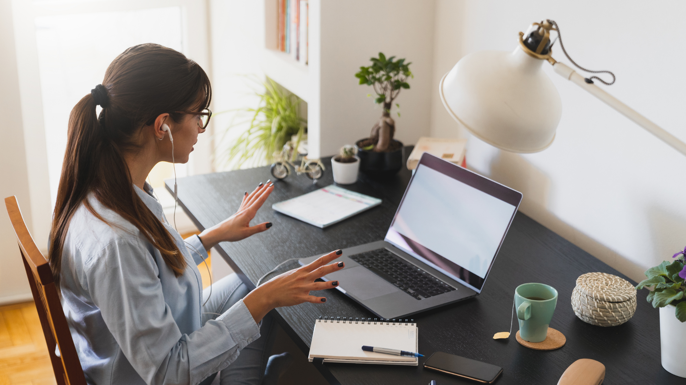 A WFH paralegal sits at her desk and receives a call via her personal computer to explain how to set up a home workspace.