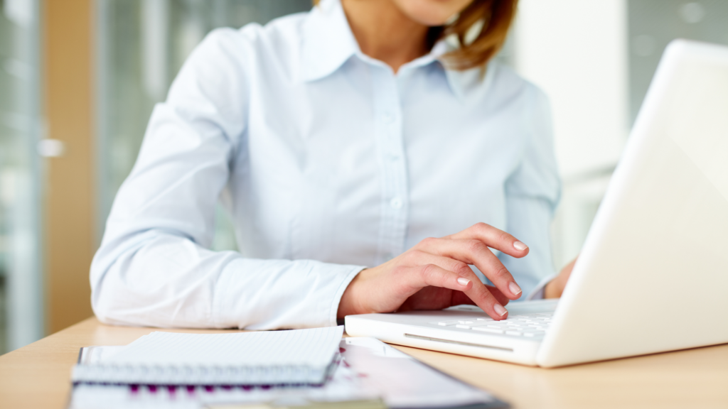 A paralegal sits confidently and writes on her computer after improving her legal writing skills for paralegals.